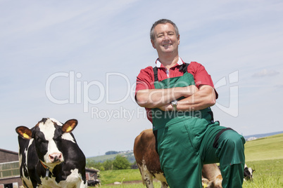 farmer with milk churns at his cows