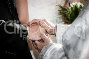 Priest holding hand blessing youg couple