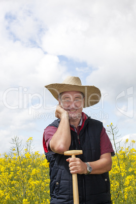 Man with straw hat in rape field