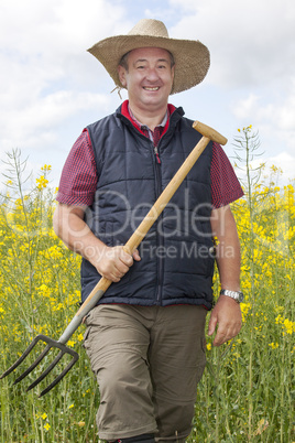 Man with straw hat in rape field