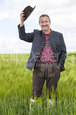 Man in corn field cancels hat in salute