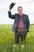 Man in corn field cancels hat in salute