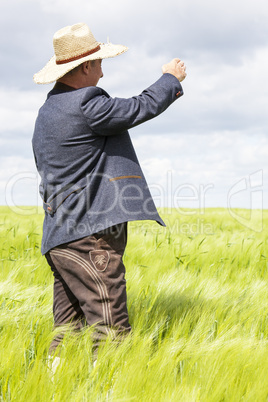 Man with hat pointing in the corn field