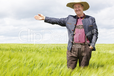 Man with hat pointing in the corn field