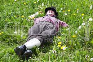 Man with hat lying in the spring meadow