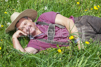 Man with hat lying in the spring meadow