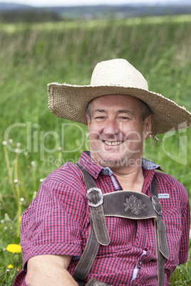 Man with hat lying in the spring meadow