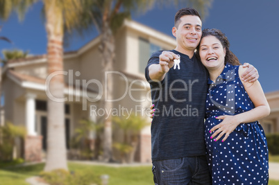 Hispanic Couple with House Keys In Front of New Home