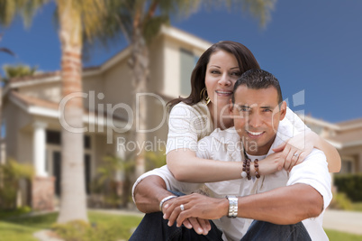 Happy Hispanic Young Couple in Front of Their New Home