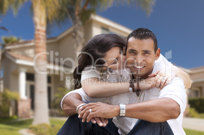 Happy Hispanic Young Couple in Front of Their New Home