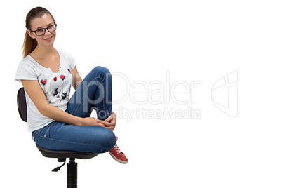 Happy teenager girl with glasses sitting on chair