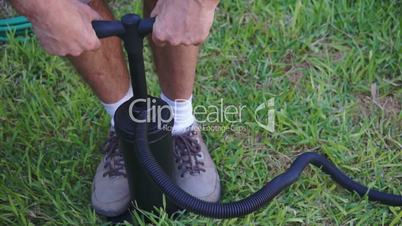 Man Using Air Pump on Grass