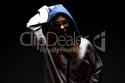 Serious teenager girl in shadow with hood