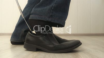 man dress shoes properly using shoehorn,