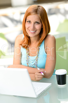 Smiling student girl sitting behind glass desk