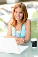 Smiling student girl sitting behind glass desk