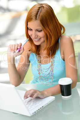 Smiling student girl working on laptop college