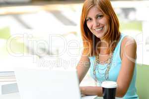 Smiling student girl with laptop at college