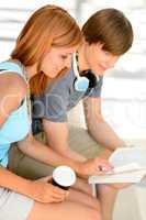 Two college students reading book while sitting