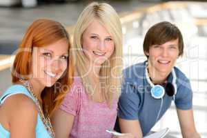 Three smiling student friends looking at camera