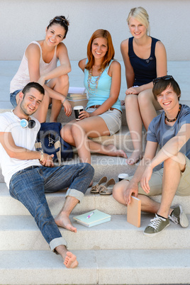 Smiling students sitting on school stairs summer