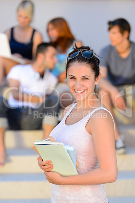 Smiling college student girl hold books summer