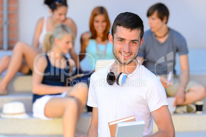 Happy student boy with books outside college