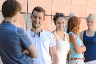 Group of friends students leaning against wall