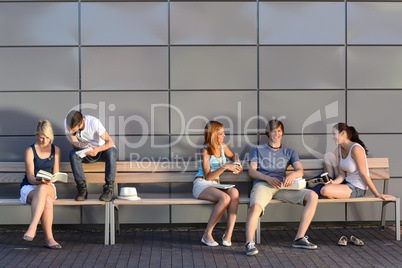 College students sitting on bench modern wall