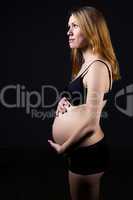 Pregnant woman in underwear holding her tummy