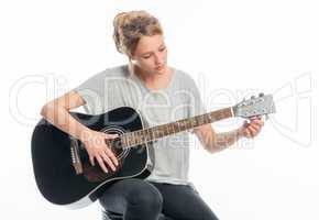Blondes Mädchen stimmt ihre Gitarre