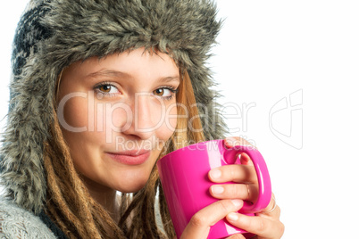 Frau mit Fellmütze hält Kaffeebecher