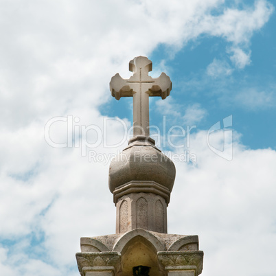 stone cross on the sky background