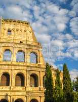 Architectural detail of Colosseum with trees at dusk, Rome