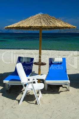 Colourful beach chairs with straw umbrellas on a beautiful sandy