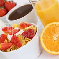 Frühstück mit Früchte Müsli, Orangen, Saft, Kaffee und Milch