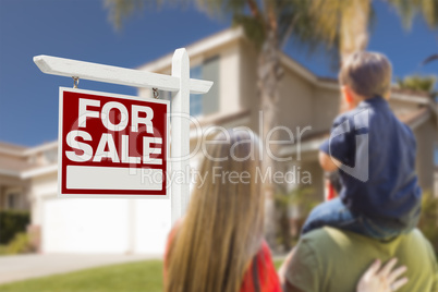 Family Facing For Sale Real Estate Sign and House
