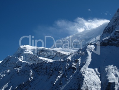 Strong wind blowing snow over a ridge