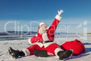 Santa Claus sitting on snow glad news in the laptop