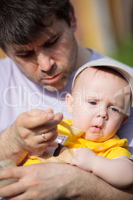Father trying to feed infant