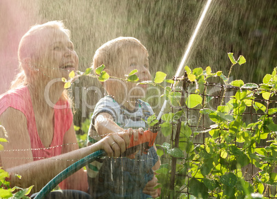 Mother and her young son playing with water