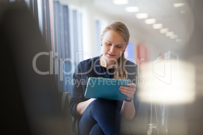 Young woman with pad in the waiting room