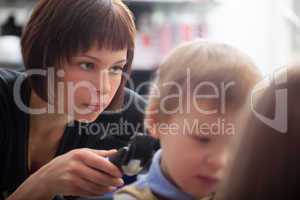 Hairstylist cutting a young boys hair