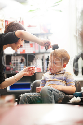 Little boy having a hair cut in a salon