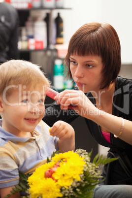 Young boy getting haircut from styist