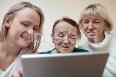 Three women using a smart tablet