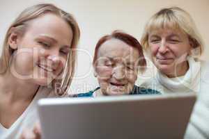 Three women using a smart tablet