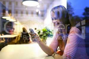 Young woman sitting in a restaurant using a mobile