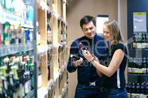 Couple choosing wine in a bottle store