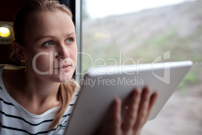Woman traveling on a train with a tablet